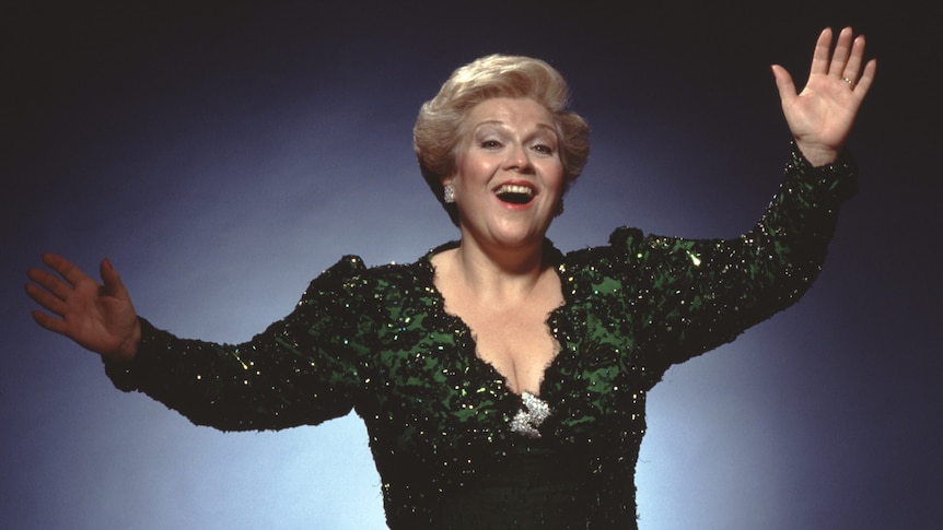 Mezzo-soprano Marilyn Horne smiling with her arms outstretched.
