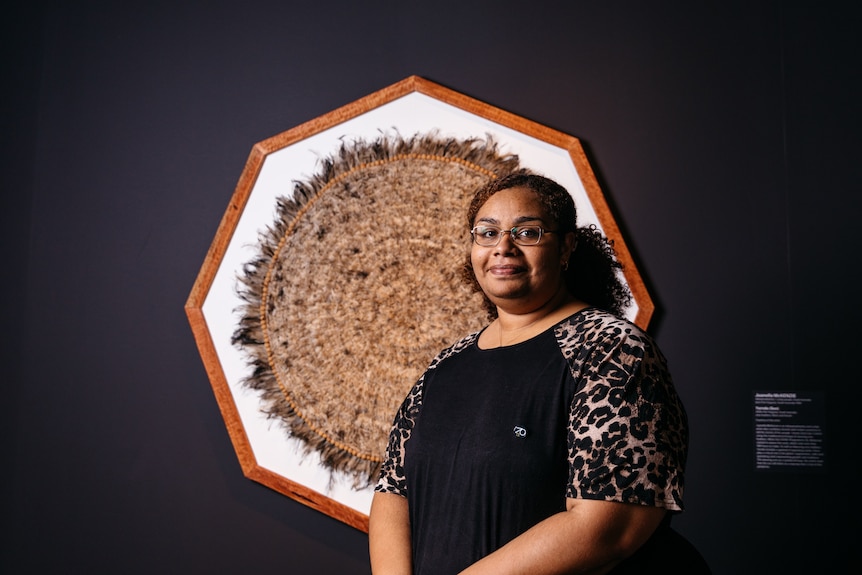 Juanella McKenzie stands in front of her Ramsay Art Prize entry, a sculpture made from emu feathers