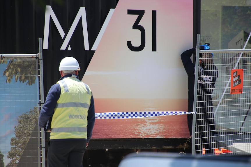 A worksafe officer and a forensics police officer at a worksite.