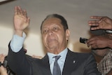 Former Haitian dictator Jean-Claude "Baby-Doc" Duvalier waves from a hotel in Petionville, Haiti