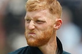 Ben Stokes scrunches up his face in as he walks at Lord's in light blue cricket kit