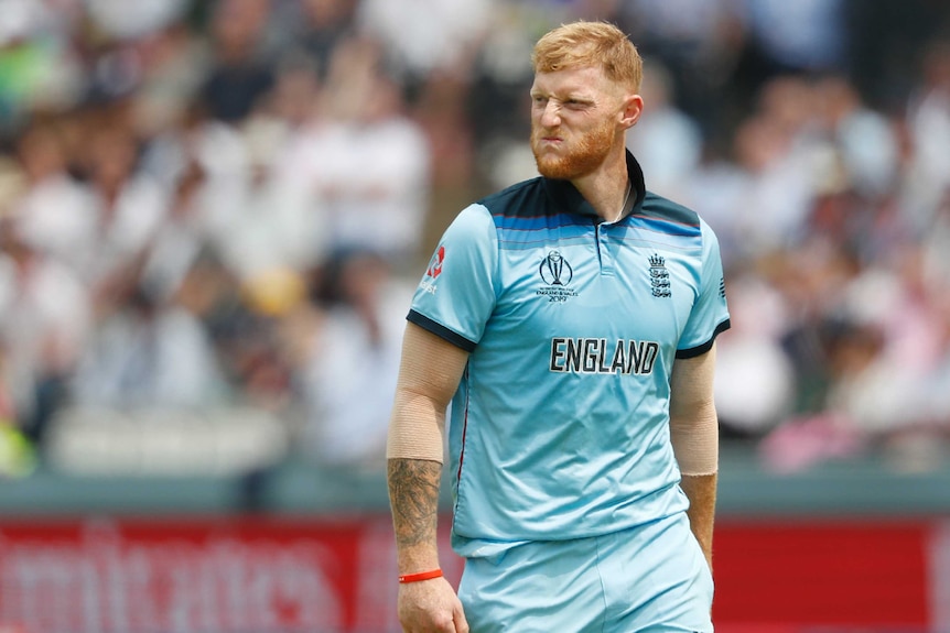 Ben Stokes scrunches up his face in as he walks at Lord's in light blue cricket kit