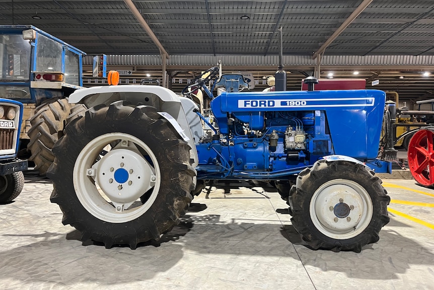A side view of a blue tractor.