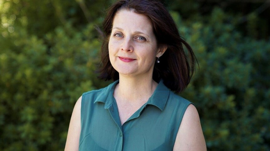 A mid-shot of Alison Xamon smiling at the camera wearing a green top.