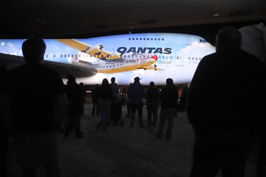 A crowd of Qantas Founders Museum staff get a sneak peek at the $3m light show