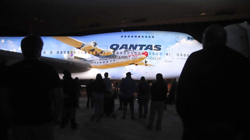 A crowd of Qantas Founders Museum staff get a sneak peek at the $3m light show