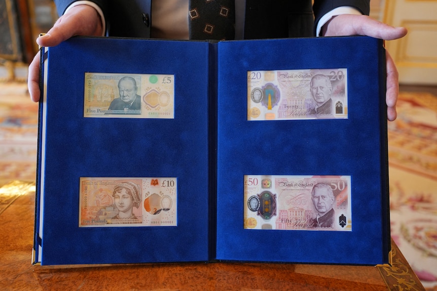 Four bank notes displayed in a book. 