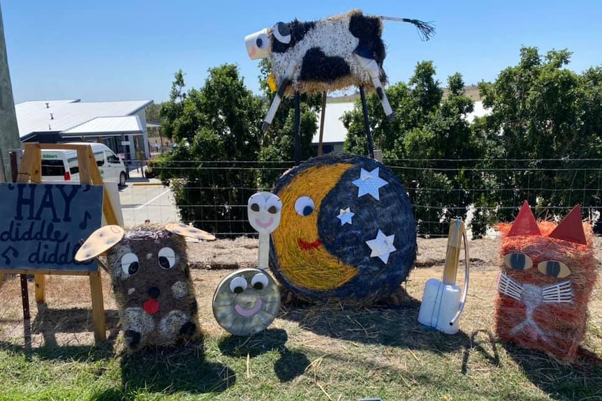 Hay bales stacked and painted to look like characters from the Hey diddle diddle nursery rhyme