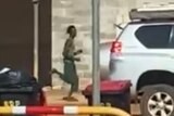 A blurry image of a tall, thin man running down a street.