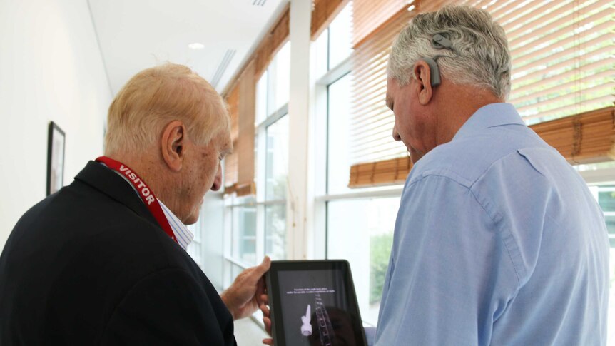 Peter Radtke from the AAA and questioner David Prest look at a photo of the eagle's ascension on an iPad.