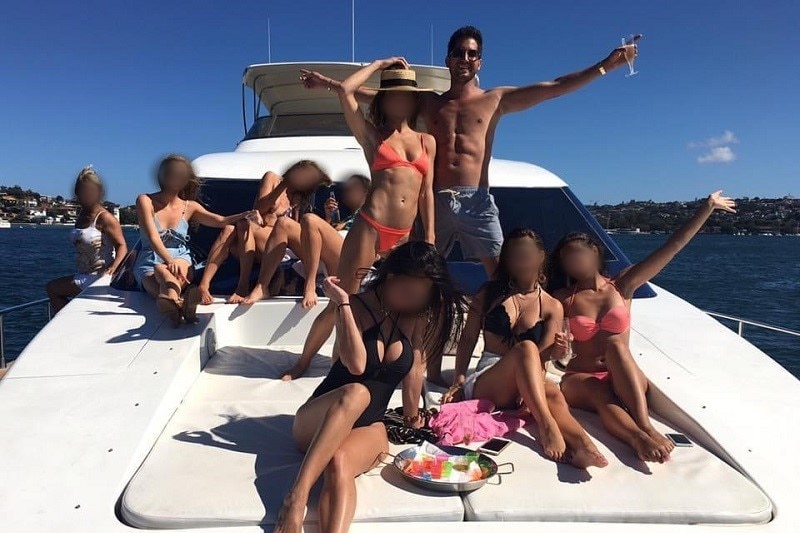 A man and eight women on board a boat.