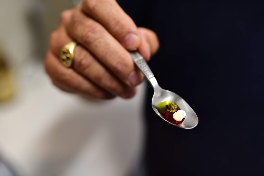 A spoon with medicines on it