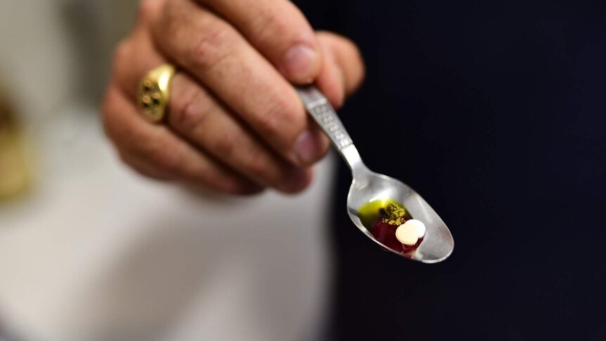 A spoon with medicines on it