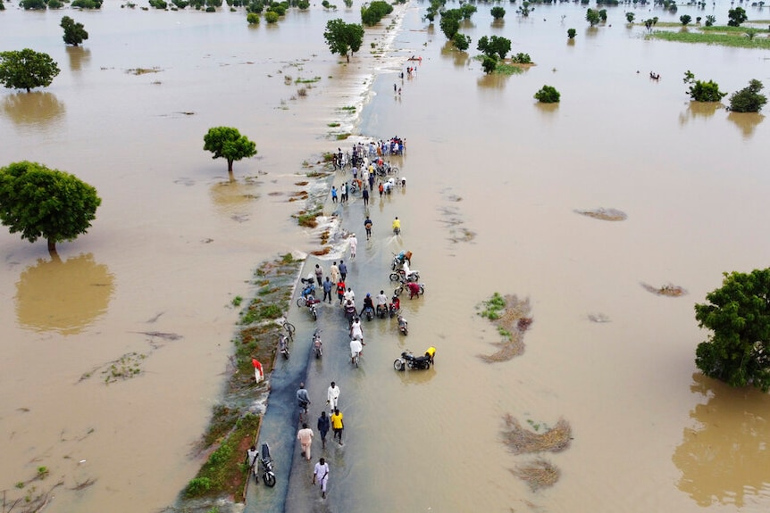 Drone view looking down at people surrounded by flood waters in Nigeria. 