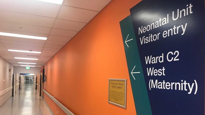 Maternity ward sign on an orange wall points down corridor inside Wollongong Hospital