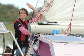 Jessica Watson waves and smiles as she sails into Sydney Harbour after her 210-day journey. (Treacy Nearmy/AAP)