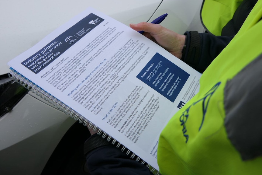 An inspector looks at paperwork ahead of a business check