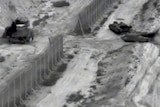Black and white video released by the IDF seeming to show Israeli military entering a gap in a border fence