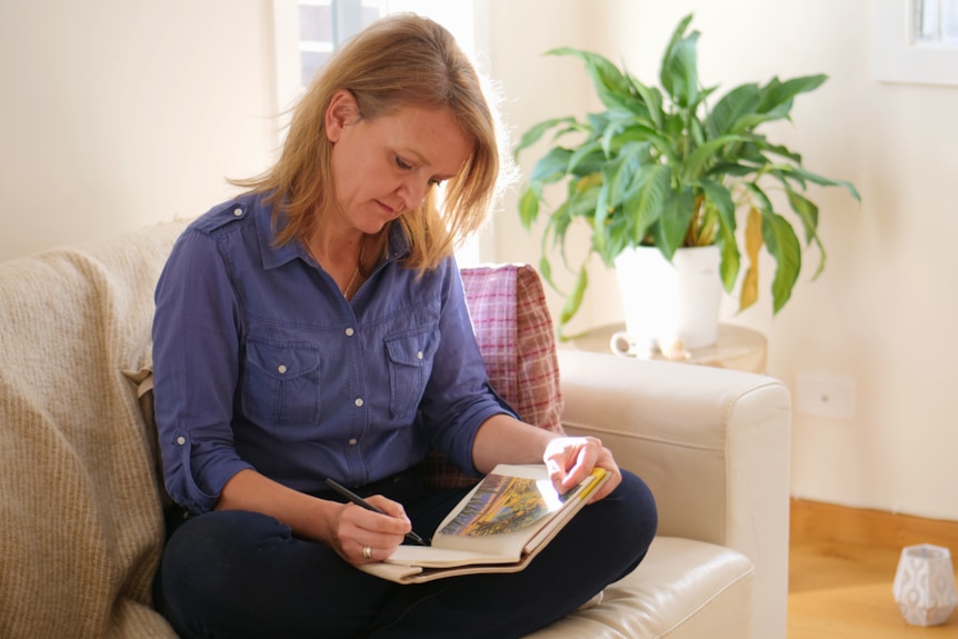 Woman on couch journaling