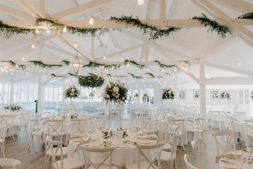 A wedding reception venue decked out in a white theme.