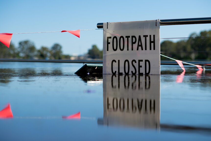 A sign reading 'footpath closed' surrounded by water