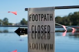 A sign reading 'footpath closed' surrounded by water