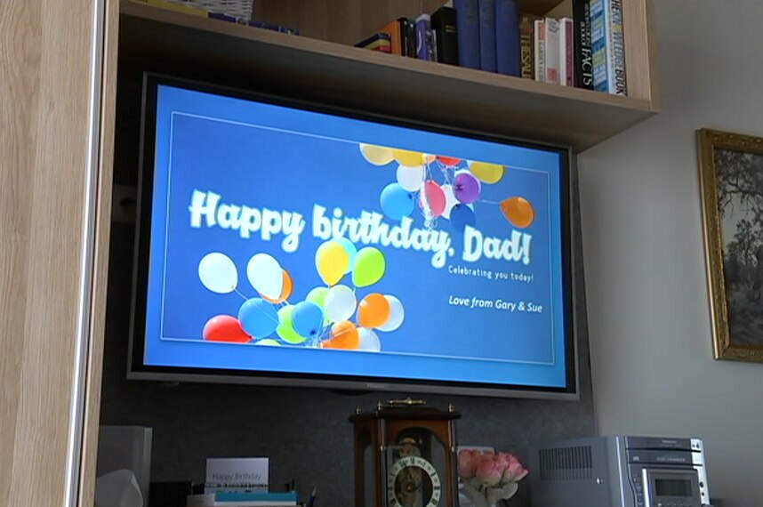 A happy birthday message displayed on a TV screen