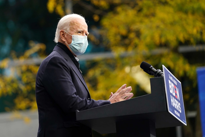 Joe Biden speaks at an event wearing a face mask