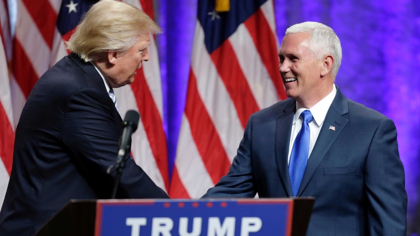 Donald Trump and Mike Pence shake hands at press event.