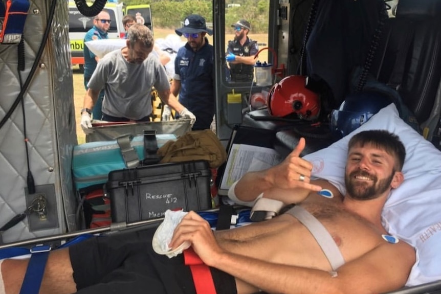 Shark victim on stretcher inside rescue helicopter.