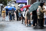 People are seen queuing outside a Centrelink office in Bondi Junction, Sydney, Tuesday, March 24, 2020.