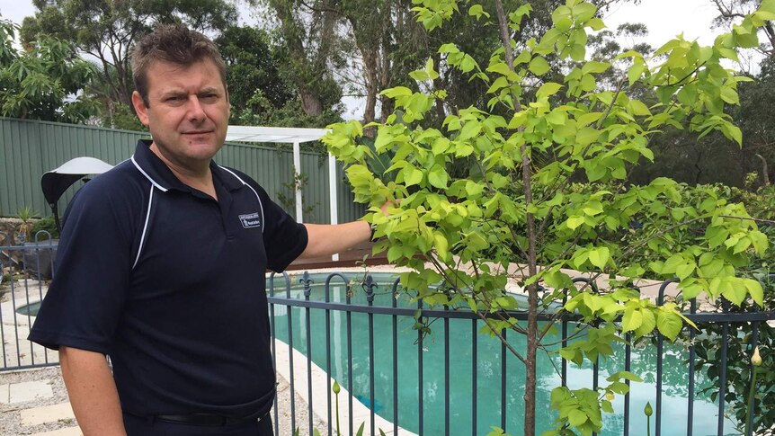 Michael Ilinsky from Royal Life Saving NSW shows that a pot plant can be used by children to climb over the pool fence
