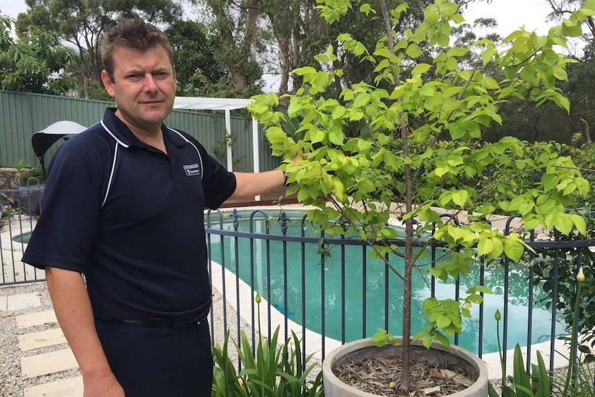 Michael Ilinsky from Royal Life Saving NSW shows that a pot plant can be used by children to climb over the pool fence