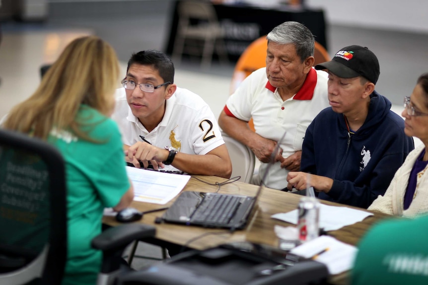 Customers sit with an insurance agent from Sunshine Life and Health Advisors.