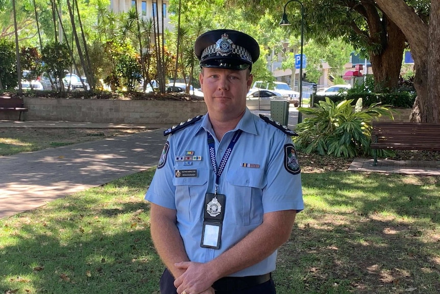 Police officer in blue uniform standing in Townsville park
