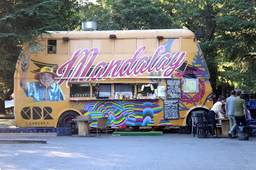 The Mandalay Bus, a double-decker, sits in a car park.