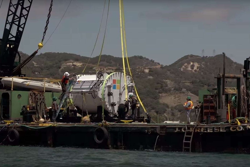 A crane launches the Microsoft data centre prototype into the ocean