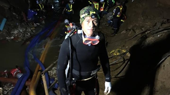 Saman Kunan in a black dive suit in a cave.