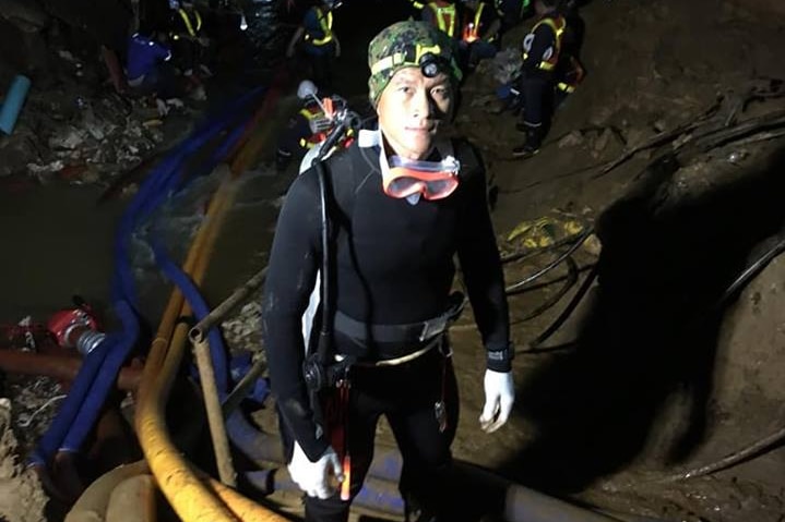 Saman Kunan in a black dive suit in a cave.