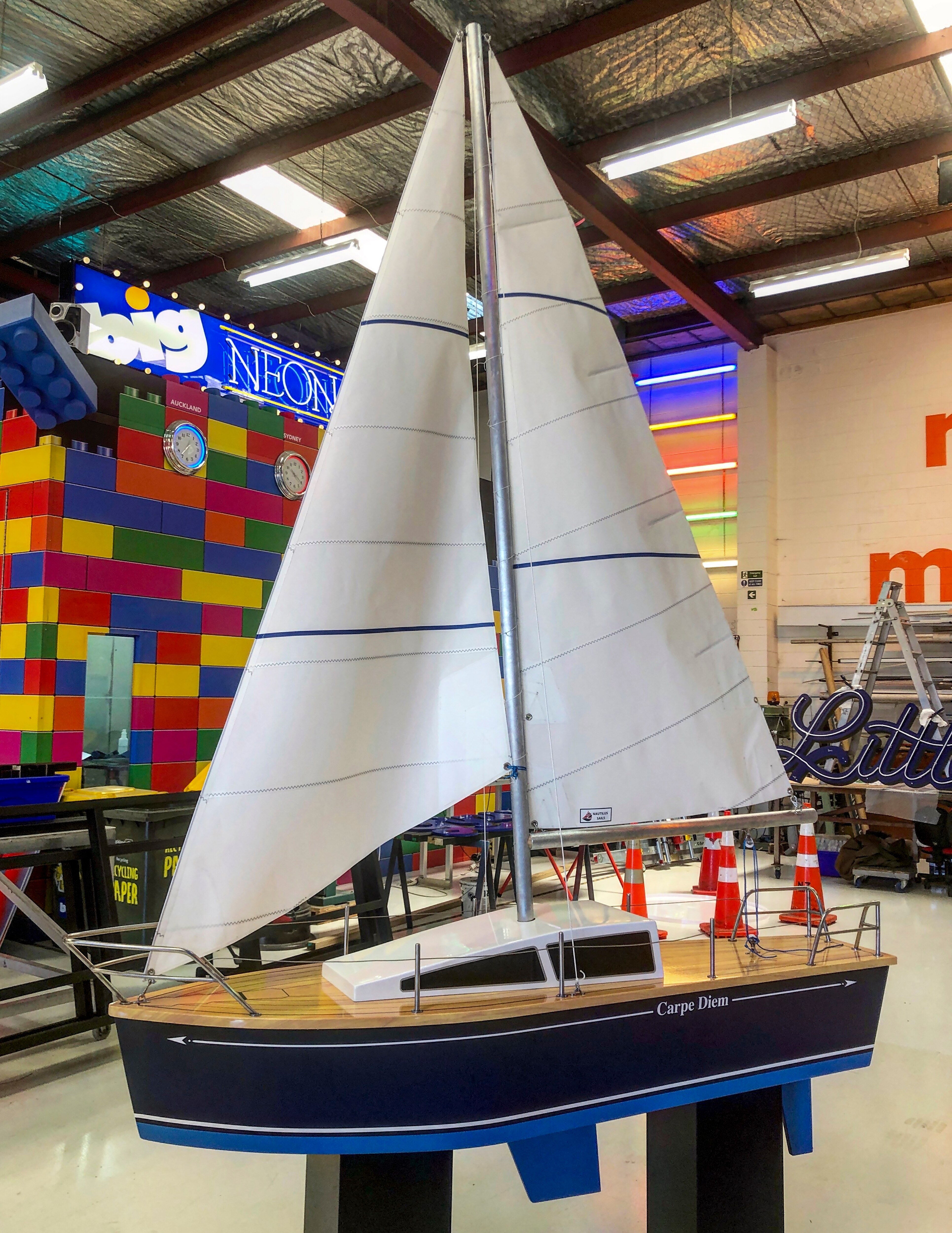 A coffin in the shape of a sailing boat. It has tall sails and a rudder.