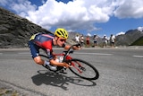 A male bike rider cycles down a mountain road at speed
