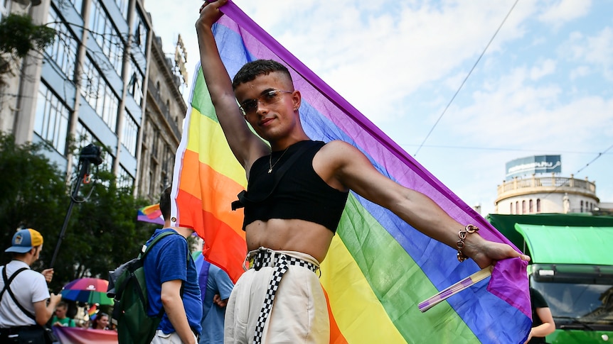 A participant poses with a rainbow flag during a gay pride parade in Budapest