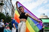 A participant poses with a rainbow flag during a gay pride parade in Budapest