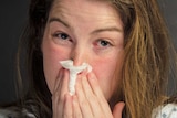 Woman with flu blowing her nose