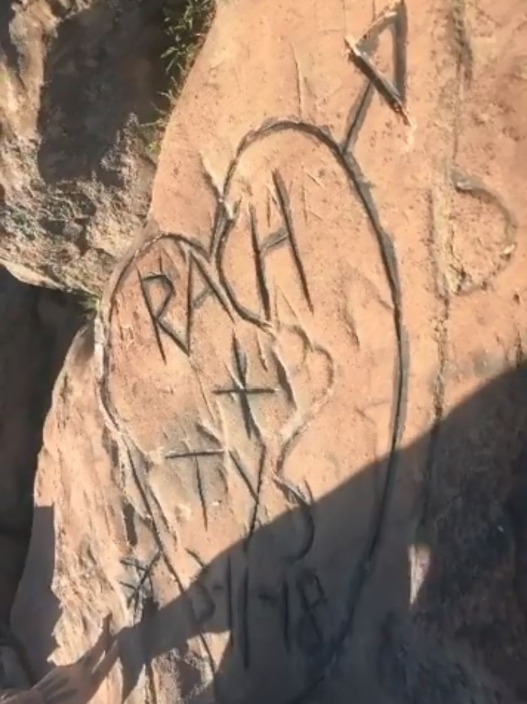 Names Rach and Tys in a love heart with an arrow through it carved into rock