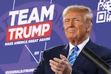 Donald Trump in front of a purple background with the words "Team Trump".