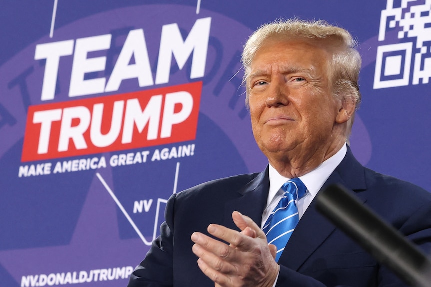 Donald Trump in front of a purple background with the words "Team Trump".
