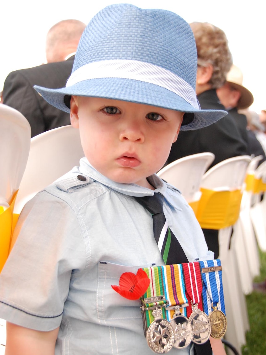 Ziggy Till wears his father's medals at the Remembrance Day service in Canberra.