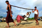Rohingya men carry a patient to a hospital outside Sittwe.