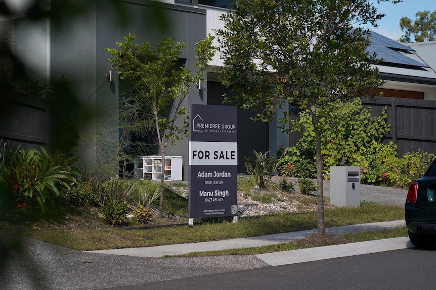 Housing sale sign in front of house